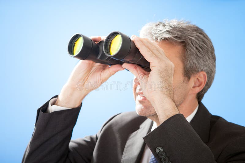 Senior businessman looking through binoculars stock photo Senior businessman looking through binoculars stock photo