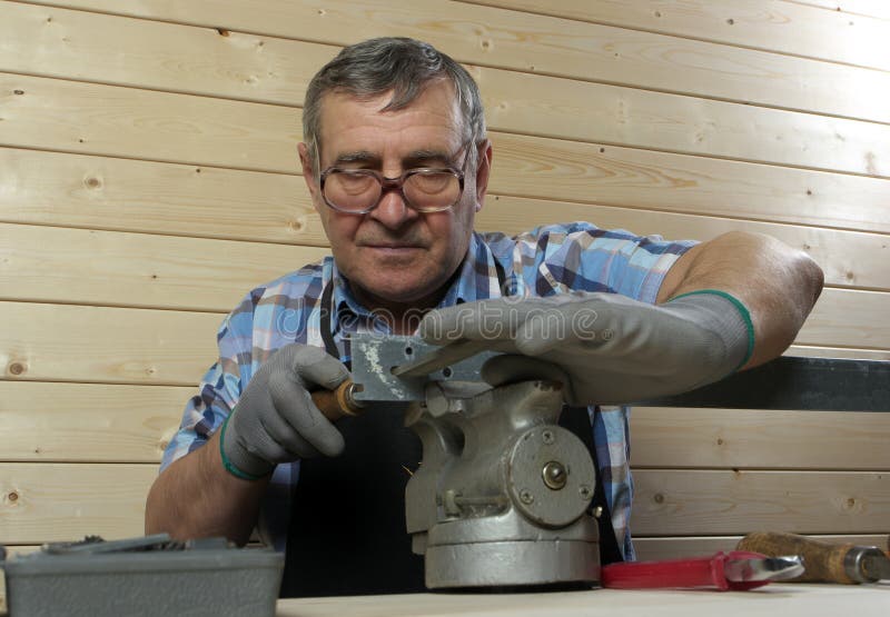 Senior Carpenter Drilling Hole in Metal Plank, in His Stock