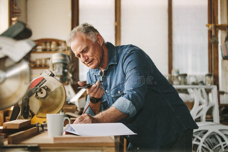 Senior carpenter working at his workshop stock photography