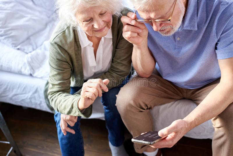 senior caucasian couple is going to make video call on phone with family, online conversation royalty free stock image