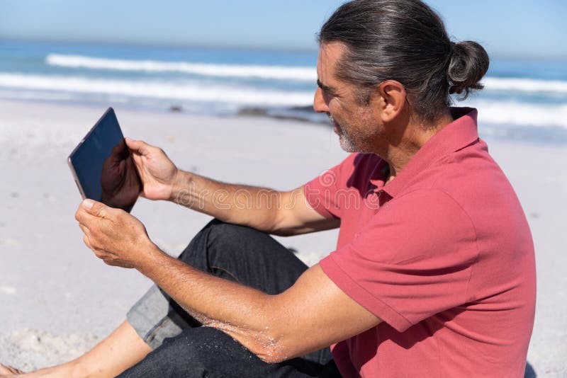 Senior Caucasian Man Using a Digital Tablet at the Beach. Stock Image ...