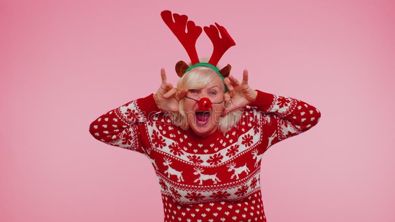 Senior Christmas grandmother woman with deer antlers listening music, dancing disco, fooling around