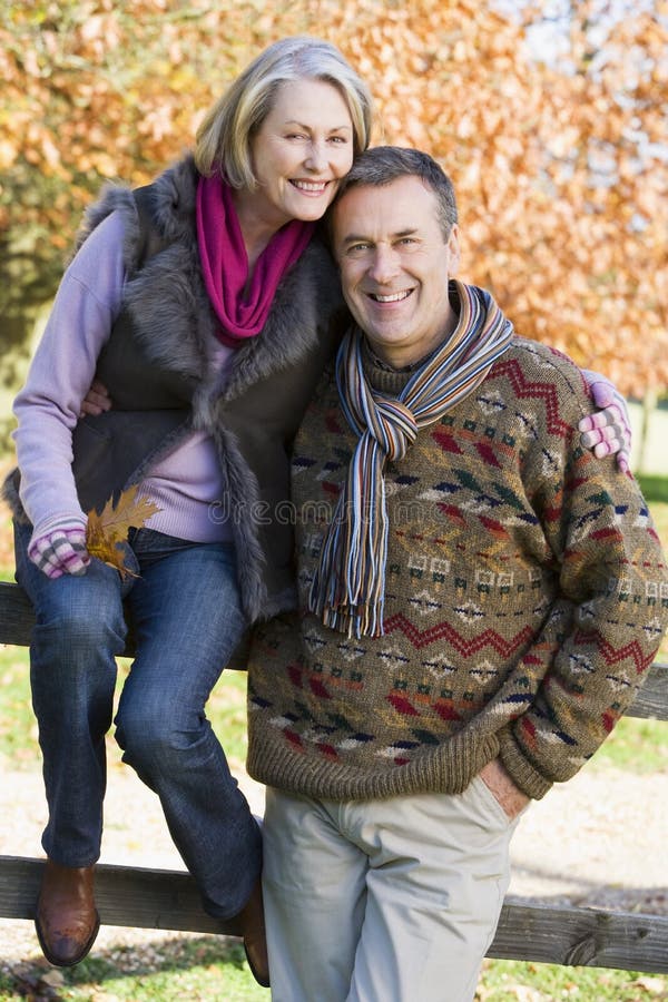 Senior couple on autumn walk with trees in background