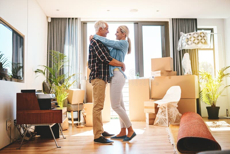 Senior couple, boxes and hug in new home for moving, retirement or excited in lounge. Man, woman and cardboard and royalty free stock photos