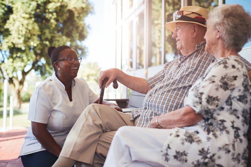 Senior couple with caregiver sitting outside royalty free stock image Senior couple with caregiver sitting outside royalty free stock image