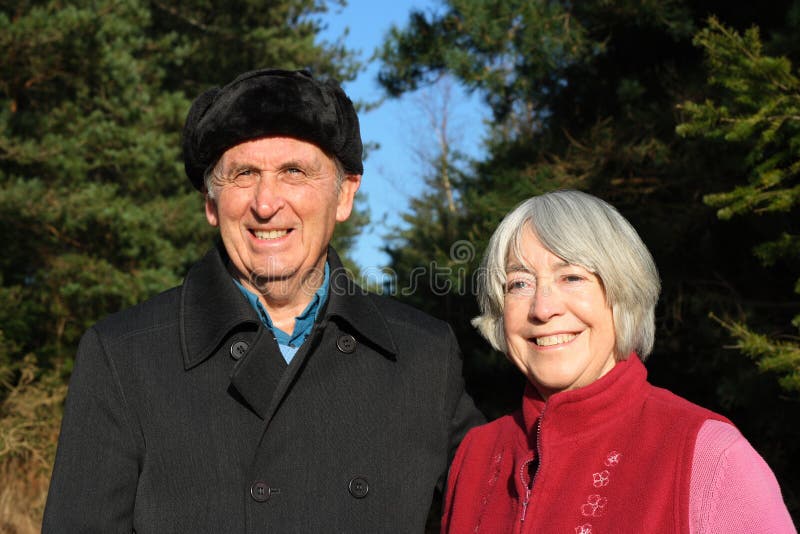 Senior couple enjoy woodland walk.