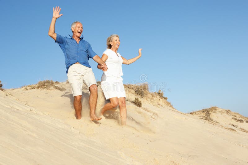 Senior Couple Enjoying Beach Holiday Running stock images