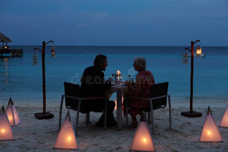 Senior Couple Enjoying Late Meal In Outdoor Restaurant