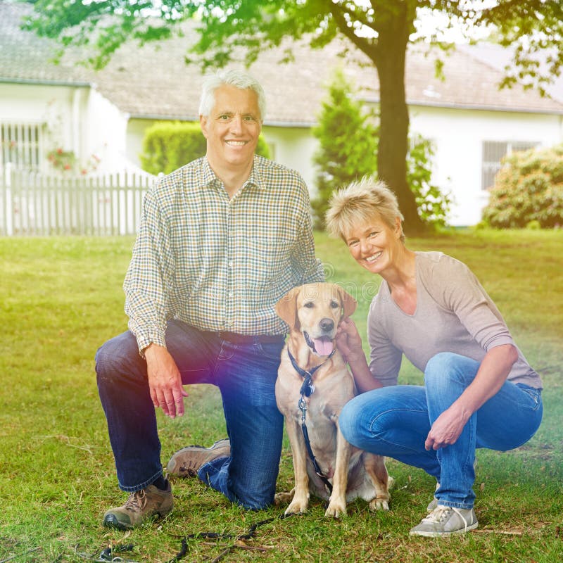 Senior couple in garden with dog royalty free stock photography Senior couple in garden with dog royalty free stock photography