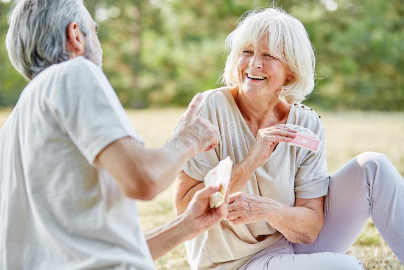 Senior couple having fun and playing a card game