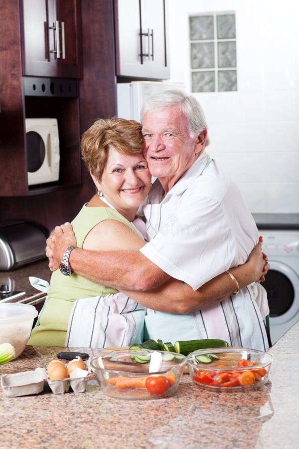 Happy loving senior couple hugging in kitchen. Joyful loving elderly couple stock images, royalty-free photos and pictures