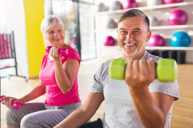 Senior couple lifting dumbbells stock photos