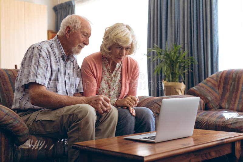 Senior Couple Making Video Call On Laptop At Retirement Home Stock