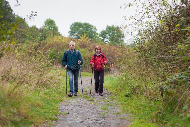 Senior couple Nordic walking on rocky trail in the nature. Senior couple Nordic walking on rocky trail in the nature.