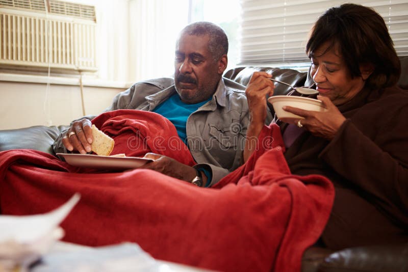 Senior Couple With Poor Diet Keeping Warm Under Blanket royalty free stock images Senior Couple With Poor Diet Keeping Warm Under Blanket royalty free stock images