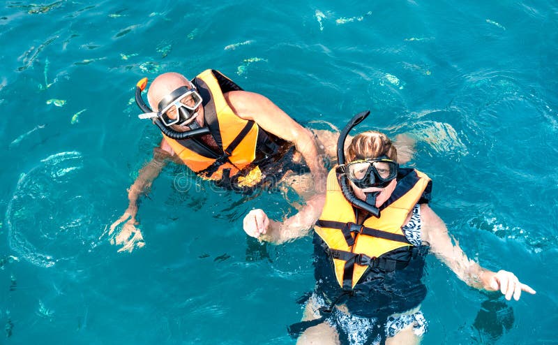 Senior couple posing for travel photo at snorkeling excursion in south east Asia during boat trip in exotic scenarios