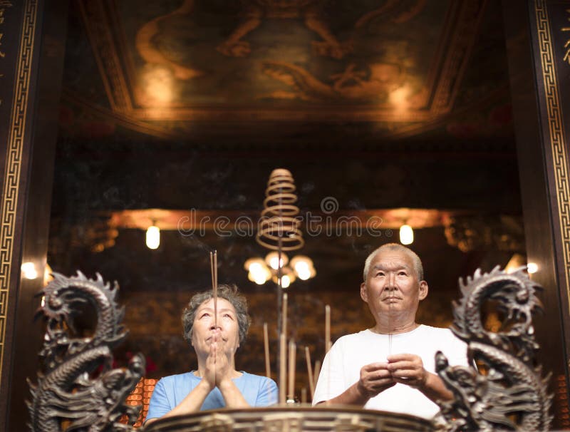 Senior couple praying buddha with incense stick