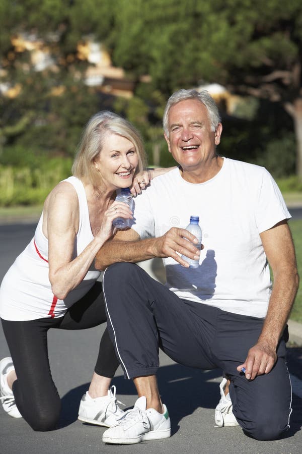 Senior Couple Resting And Drinking Water After Exercise stock photo