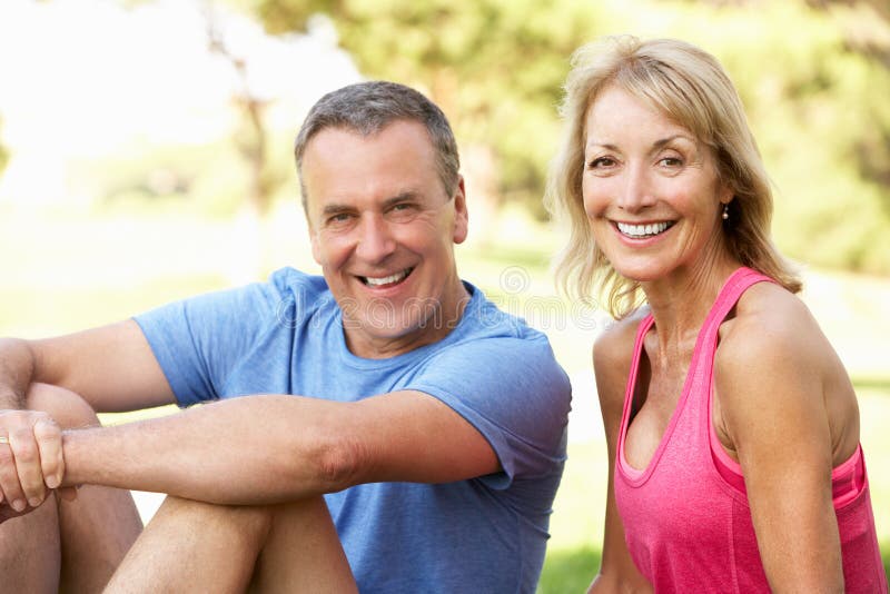 Senior Couple Resting After Exercising In Park stock photography