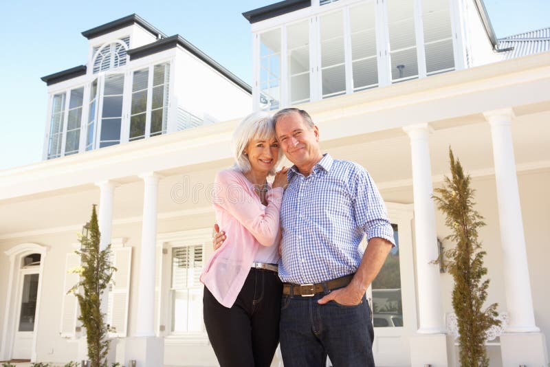Senior Couple Standing Outside Dream Home Smiling At Camera. Happy embracing couple stock images, royalty-free photos and pictures