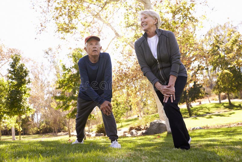 Senior Couple Stretching Whilst Exercising Together In Park royalty free stock image Senior Couple Stretching Whilst Exercising Together In Park royalty free stock image