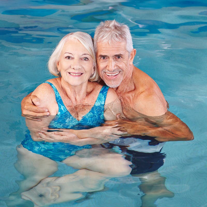 Senior couple swimming in pool stock photos Senior couple swimming in pool stock photos