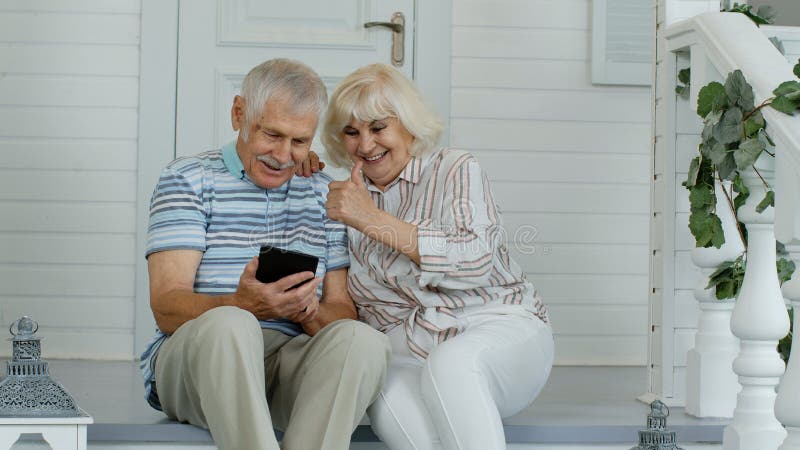 Senior Couple Using Digital Tablet in Porch at Home. Watching Funny Videos  on Social Media Network Stock Image - Image of modern, news: 199342695