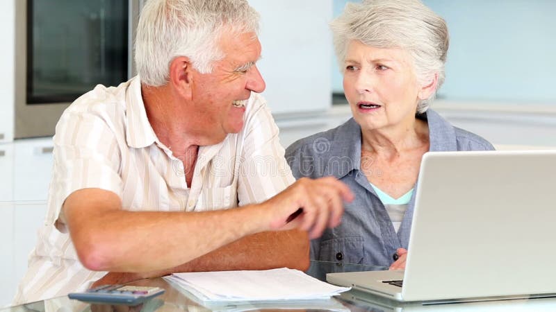 Senior couple using laptop to pay their bills