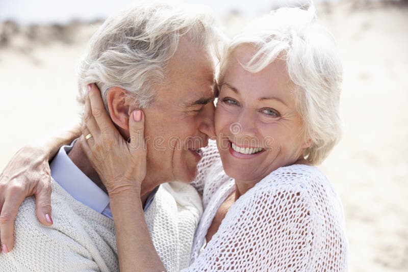 Senior Couple Walking Along Beach Together