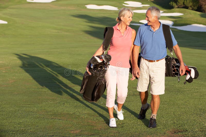Senior Couple Walking Along Golf Course