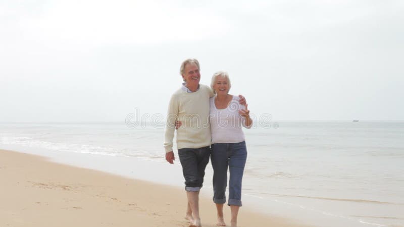 Senior Couple Walking Along Misty Beach