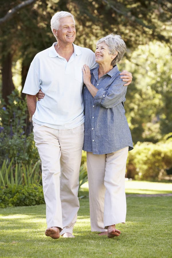 Senior Couple Walking In Garden At Home