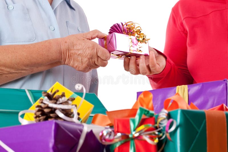 Senior and daughter reaching gift to each other royalty free stock photography Senior and daughter reaching gift to each other royalty free stock photography