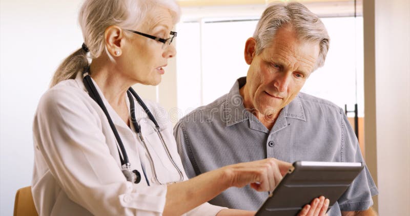 Senior doctor expressing health concerns with elderly man patient royalty free stock photography Senior doctor expressing health concerns with elderly man patient royalty free stock photography