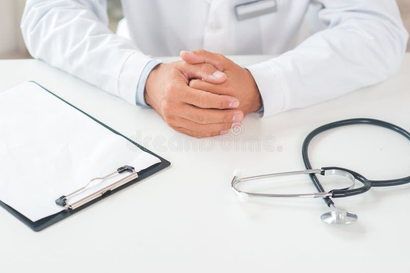 Senior doctor at his office in hospital working close-up sitting still top view stock photo Senior doctor at his office in hospital working close-up sitting still top view stock photo
