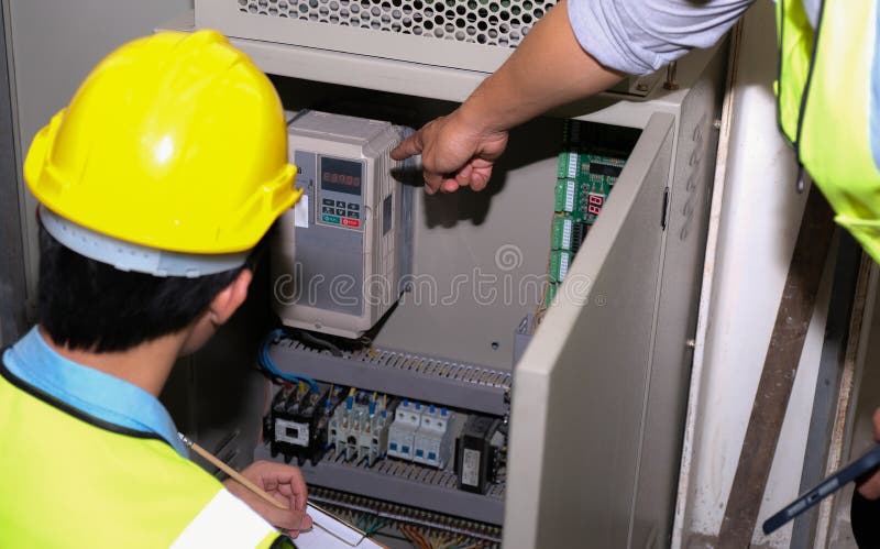 Senior electrician engineer pointed at the power generator and talked with junior engineer
