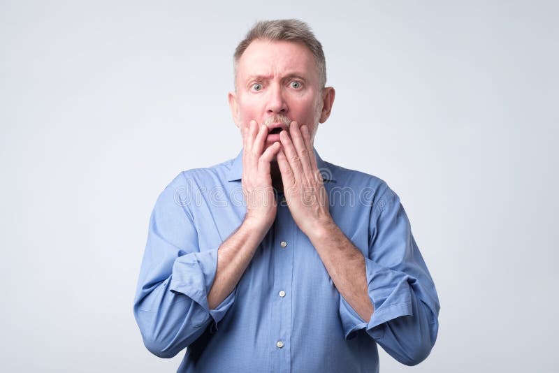 Senior european man with scared and anxious expression, bites finger nails stock photos Senior european man with scared and anxious expression, bites finger nails stock photos