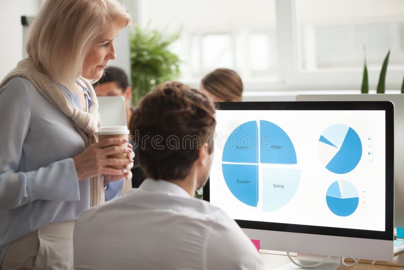 Senior executive checking annual report on computer screen helpi stock photography