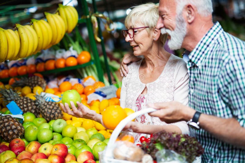 Senior family couple choosing bio food fruit and vegetable on the market during weekly shopping