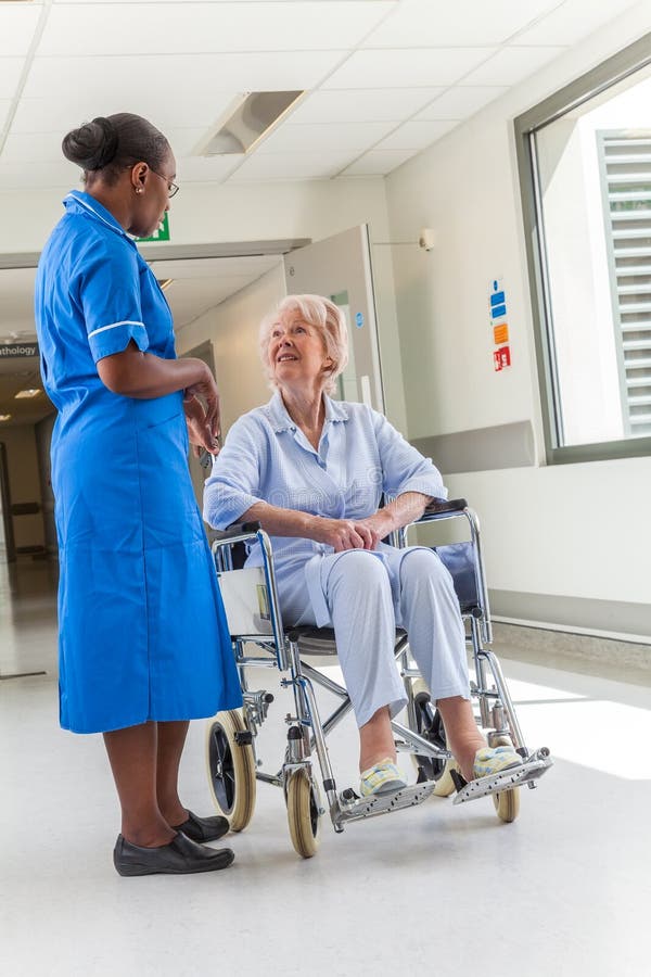 Senior Female Patient in Wheelchair & Nurse in Hospital royalty free stock photos Senior Female Patient in Wheelchair & Nurse in Hospital royalty free stock photos