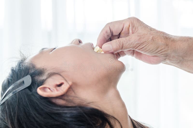 Senior hand feeding popcorn for her grandchild