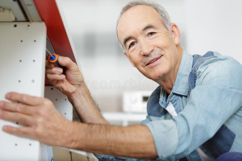 Senior Handyman Assembling Kitchen Cupboard Stock Image Image of wood