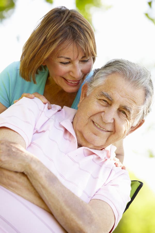 Senior Hispanic Couple Relaxing In Park