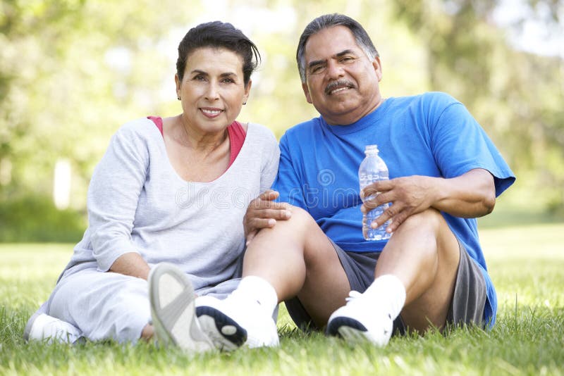 Senior Hispanic Couple Resting After Exercise stock photo