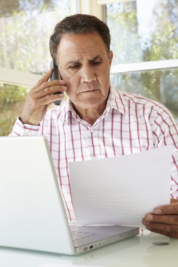 Senior Hispanic Man Working In Home Office