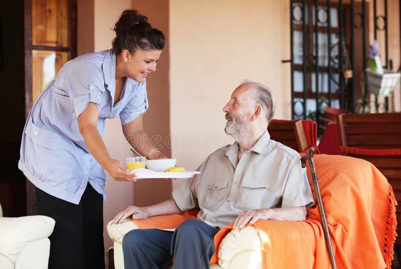 Anziani senior di essere portato pasto da parte di un accompagnatore o di un infermiere, per la cura a casa.