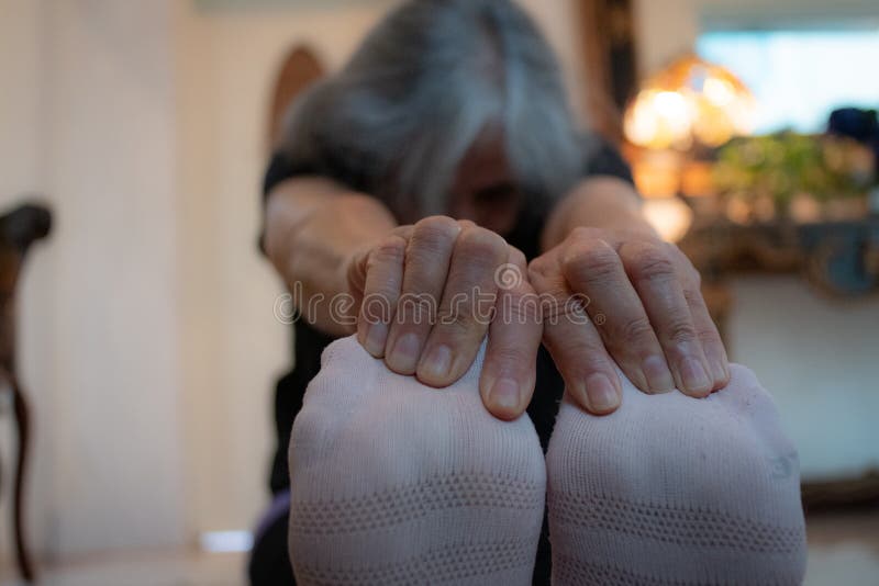 Senior Indian woman with grey hair and glowing skin, meditating in the morning.