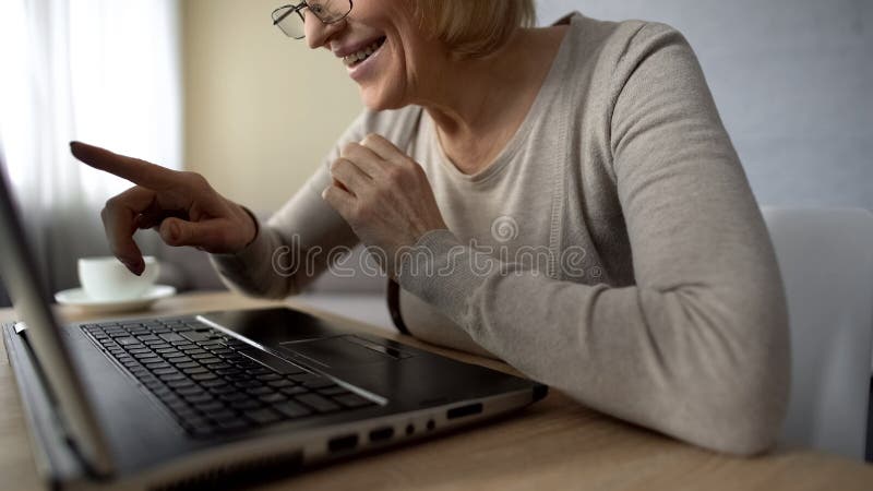 Senior lady delighted to talk to children in internet, looking at laptop screen royalty free stock photos Senior lady delighted to talk to children in internet, looking at laptop screen royalty free stock photos