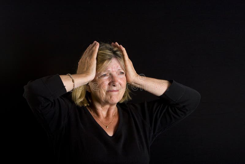 Shot of a Senior Lady with Hands on her Head, against a Black Background. Shot of a Senior Lady with Hands on her Head, against a Black Background