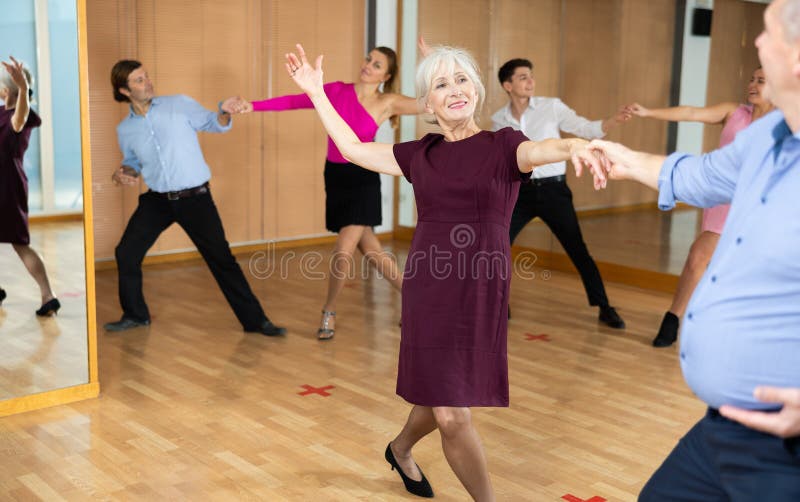 Senior Lady Learning Swing Dance with Partner in Horeography Class